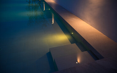 Modern swimming pool for family lifestyle at night. Pool lighting design.