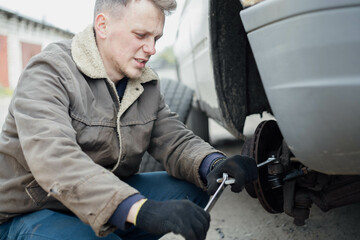 a man repairs a car, replacing steering tips