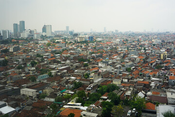 Fototapeta premium Surabaya, Indonesia - May, 2022 : View of Surabaya city from the top floor of a very high building so that settlements and tall buildings can be seen. Port, center of business, trade and government.