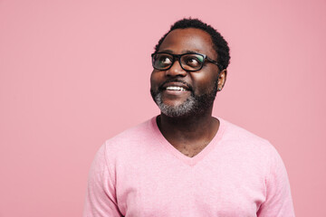 Fototapeta premium Black bearded man in eyeglasses smiling and looking aside