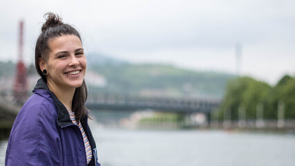 smiling girl sitting in front of the river