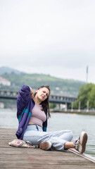 Fototapeta na wymiar smiling girl sitting in front of the river