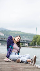 smiling girl sitting in front of the river