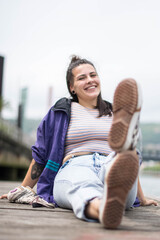 smiling girl sitting in front of the river