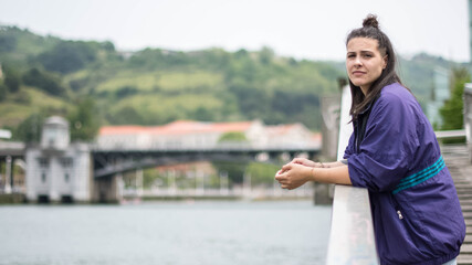 smiling girl sitting in front of the river