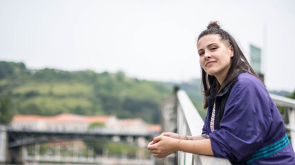smiling girl sitting in front of the river