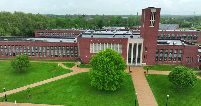 Aerial truck shot of school. High school on rainy, cloudy day in spring. Educational building.