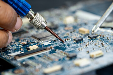 Technician repairing inside of mobile phone by soldering iron. Integrated Circuit. the concept of...