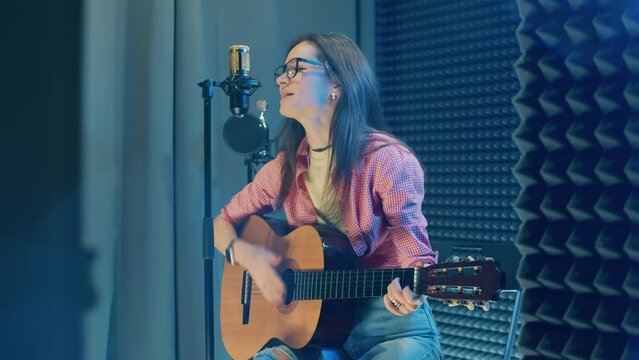 A singing lady is getting recorded in the studio