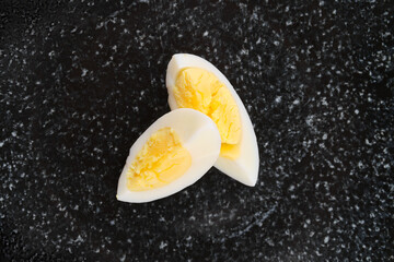 Overhead view of half of boiled egg cut on two pieces