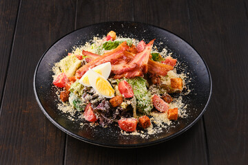 Salad with bacon, egg, fresh vegetables and croutons
