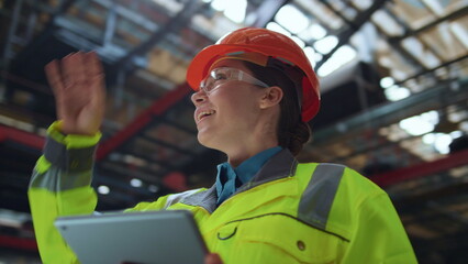 Joyful woman supervisor smiling at huge digital modern production warehouse.