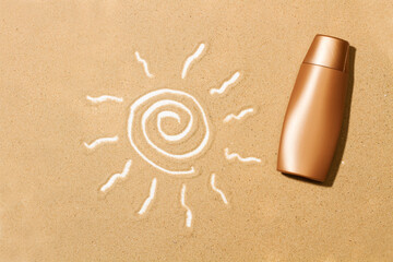 Botella de crema de protección solar sobre arena con un dibujo de sol. Vista superior y de cerca. Copy space