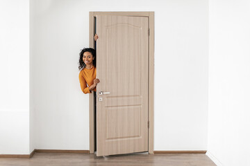 Cheerful African American Woman Opening The Door Smiling Standing Indoors