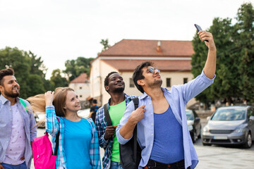 Fototapeta na wymiar The joyful group of multiethnic students taking a selfie outdoors