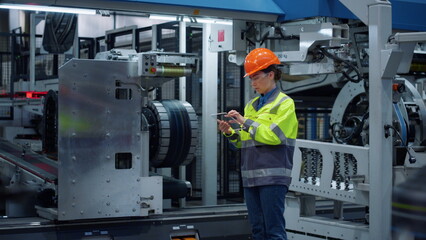 Supervisor holding tablet with transparent glass screen on modern factory.