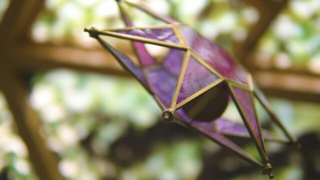close up of purple 8 pointed star represting the universe from chinese culture in spiritual environment slow motion depth of field blurry backround