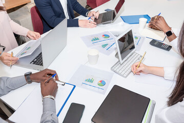 Teamwork with business people analyzes the cost chart on the desk in the meeting room