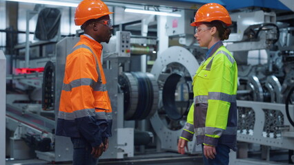 Businesspeople shaking hands at machinery plant. Cheerful team work concept.