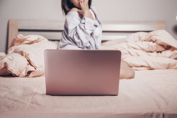 focus on the laptop. at the laptop, a young Asian girl enjoys and shows her charms. low depth of...