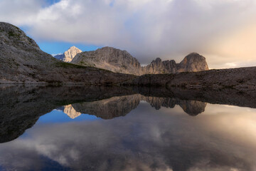 Fototapeta na wymiar Sunset in the mountains of the Julian Alps. Evening reflections in the mountain lake.
