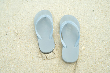 selective focus on pastel blue sandals on the white sand beach