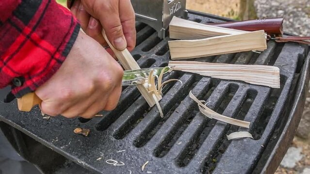 Zeitlupe Filmmaterial  St&uuml;ck Fichte Holz wird mit scharfen Jagd Messer Holzfedern geschnitzt um Feuer machen mit Feuerstahl und Hobo Kocher, Deutschland