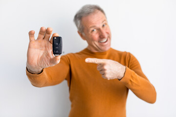 Fototapeta na wymiar Excited Man Holding Car Key And Pointing, White Background