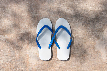 Fototapeta na wymiar white and blue color slipper on concrete floor in a shade, casual shoes and footwear