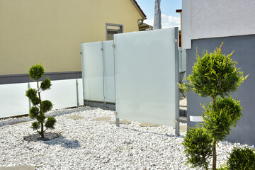 Terrasse und Gartenbereich hinter einem Reihenhaus mit Milchglaswand-Sichtschutz des Essbereichs