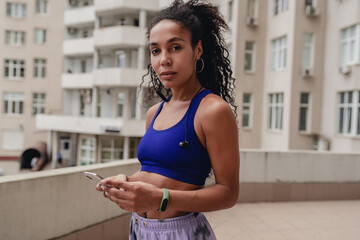 attractive black african american woman in sport fitness outfit on rooftop making work out