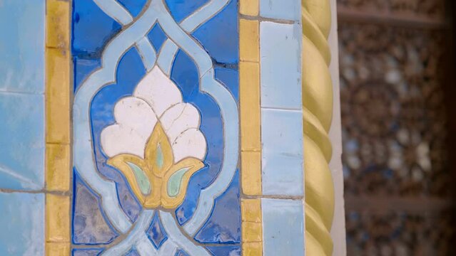 Beautiful colorful ceramic tiles with oriental type floral pattern glisten with voluminous textures and reflect the surroundings. Closeup. Shot in motion