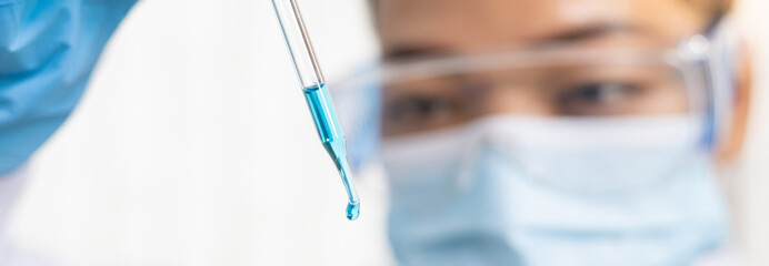 Scientists are carrying blue chemical test tubes to prepare for the determination of chemical composition and biological mass in a scientific laboratory, Scientists and research in the lab Concept.