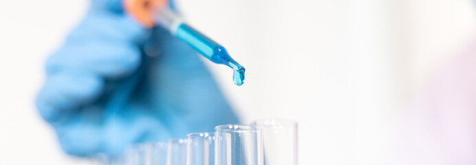 Scientists are carrying blue chemical test tubes to prepare for the determination of chemical...