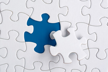 Obraz premium Piece of jigsaw puzzle on blue paper. Directly above. Copy space.