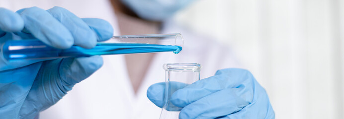 Scientists are carrying blue chemical test tubes to prepare for the determination of chemical...