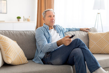 Mature guy spending weekend watching tv at home