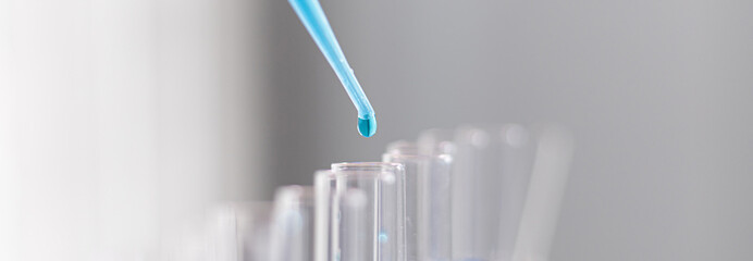 Scientists are carrying blue chemical test tubes to prepare for the determination of chemical...