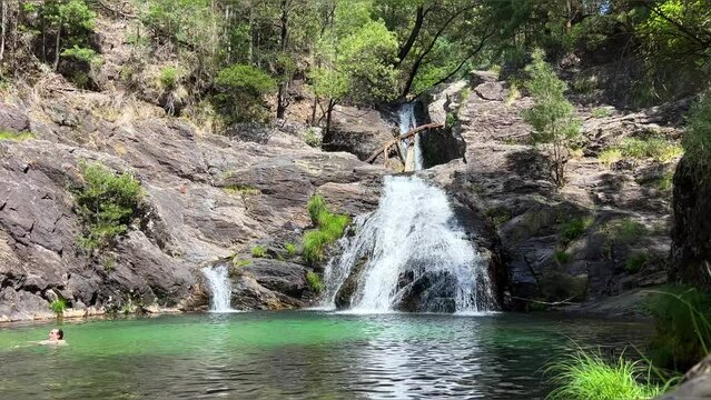 Paradise Place in the jungle mountain lake with a waterfall on the left side a man swims everywhere green trees and a transparent Lake extraordinary beauty Like from adventure films. High quality 4k