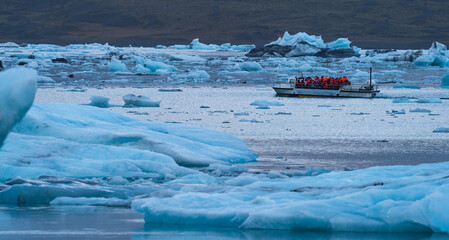 Icebergs on Jokulsarlon lagoon in Iceland with tourist boat