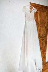 The wedding dress is hanging on the door. The Bride's Gathering