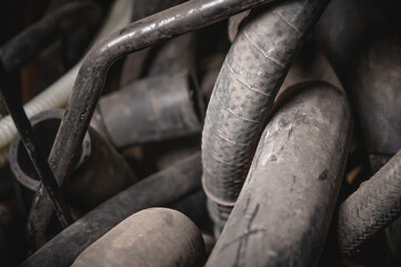 Rubber pipes and hoses leading from the car radiator to the engine, view of the engine from below. old worn rubber car cooling system hoses