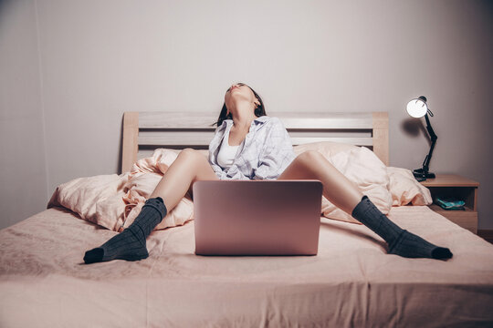 a young Asian webcam model girl is sitting in front of a laptop with her legs spread. she communicates and shows her charms. low depth of focus,artistic photo processing