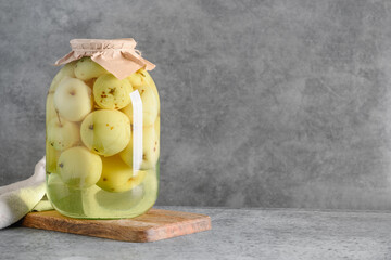 Homemade delicious canned apple compote in large glass jars on gray table. Space for text.