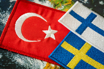 The Turkish flag next to the flags of Finland and Sweden. Concept of a political conflict between a...