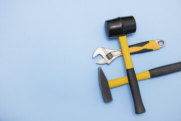 hammer, mallet, sanitary key on a light blue background with copy space