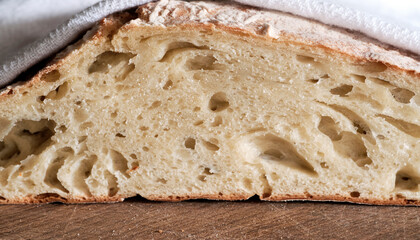 ciabatta, rustic bread cools under a white towel