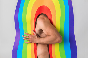 a muscular man stucks in the arch with rainbow pattern, concept of LGBTQ pride, LGBTQ people, LGBTQ...