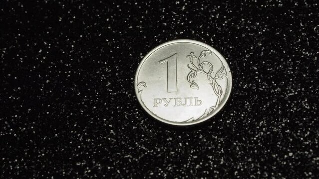Russian ruble coin on black glitter background moving on a turntable