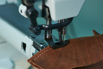 A powerful sewing machine stitches thick leather.